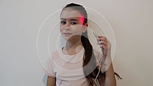 Little girl treating ear with infrared light.