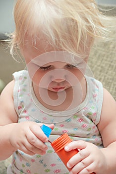 A little girl tries to inflate soapy water balls. Child and soap bubbles