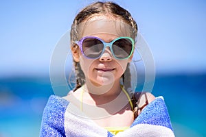 Little girl at tropical beach covered with towel