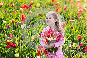 Little girl in tulip flower garden