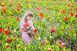 Little girl in tulip flower garden