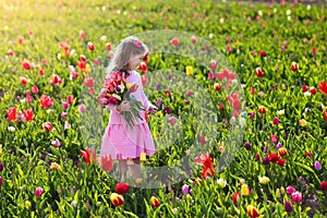 Little girl in tulip flower garden