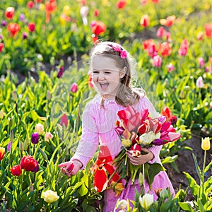 Little girl in tulip flower garden