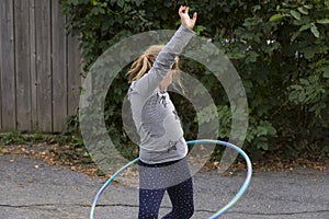 Little girl twisting her hips while playing with her hula hoop