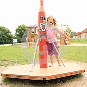 Little girl twisting on a merry-go-round