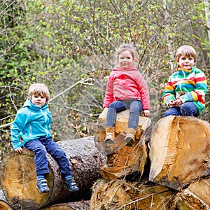 Little girl and two boys playing together in forest