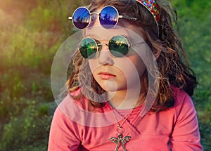 Little girl in two pairs round colored glasses