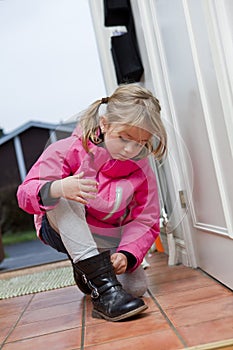 Little girl tying her shoes