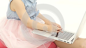 Little girl types the text on the keyboard. White background