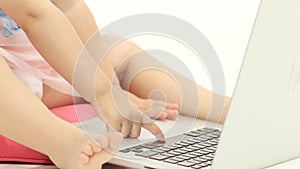 Little girl types the text on the keyboard. White background. Close up