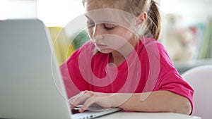 Little girl typing on laptop keyboard