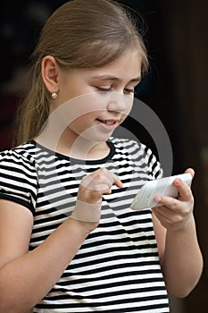 Little girl typing sms on a smartphone