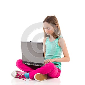 Little girl typing something on a laptop