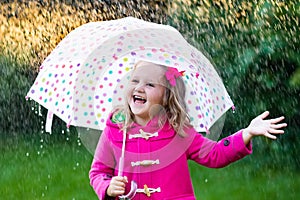 Little girl with umbrella in the rain