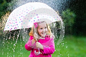 Little girl with umbrella in the rain