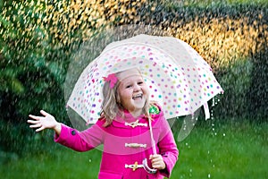 Little girl with umbrella in the rain