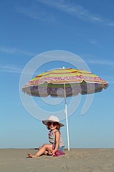 Little girl under sunshade photo