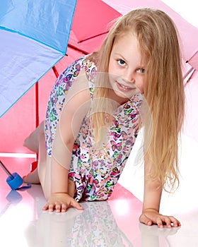 Little girl under an umbrella.