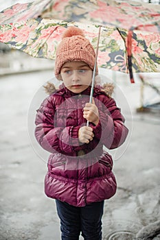 Little girl under the umbrella outside, rainy day. Little girl walks with umbrella under the rain