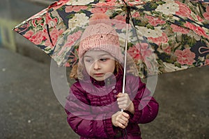 Little girl under the umbrella outside, rainy day. Little girl walks with umbrella under the rain