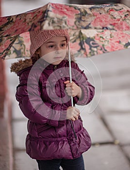 Little girl under the umbrella outside, rainy day. Little girl walks with umbrella under the rain