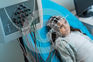Little girl undergoing electroencephalography procedure photo