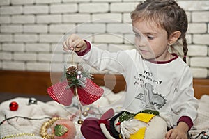 A little girl unpacks a box with Christmas decorations. New Year`s decorations. Christmas mood.