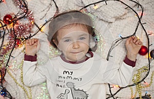 A little girl unpacks a box with Christmas decorations. New Year`s decorations. Christmas mood.