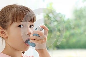 Little girl using asthma inhaler