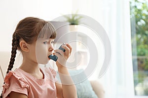 Little girl using asthma inhaler