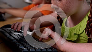 Little girl using computer in classroom in school