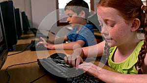 Little girl using computer in classroom in school