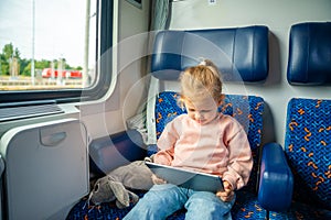 Little girl using digital tablet during traveling by railway, Europe