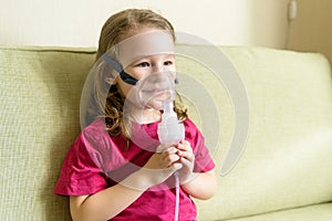 Little girl using inhaler mask at home