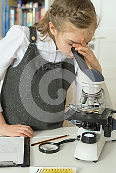 Little girl using microscope.