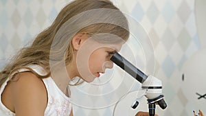 A little girl using a microscope