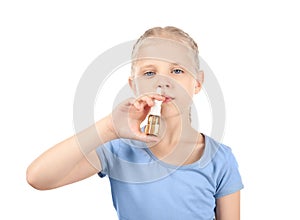 Little girl using nasal drops on white background. Allergy concept photo