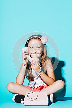 Little girl using pink analogue phone