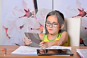 Little girl using a Tablet PC and an Ebook for homework