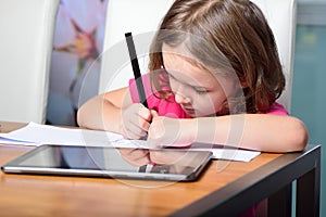 Little girl using a Tablet PC for homework