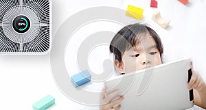 Little girl using tablet in room with modern air purifier