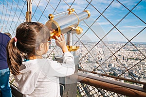 Little girl using the telescope in the Eiffel Tower