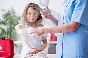 Little girl visiting old female doctor