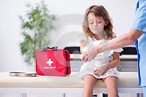 Little girl visiting old female doctor