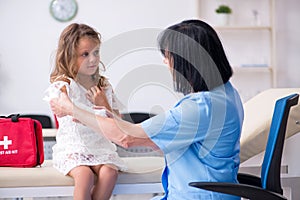 Little girl visiting old female doctor