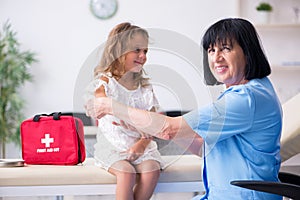 Little girl visiting old female doctor