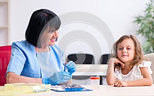 Little girl visiting old female doctor