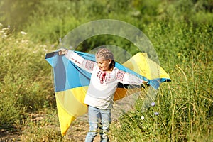 Little girl in vyshyvanka with flag of Ukraine