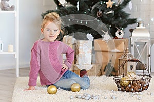 Little girl waiting for a miracle in Christmas decorations