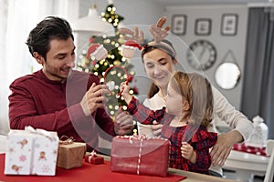 Little girl waiting for opening Christmas presents